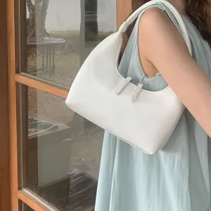 White glossy PU leather hobo underarm bag detail view showing smooth crescent shape curve.