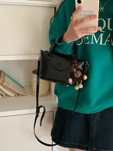 Chic black mini handbag for women, versatile PU leather crossbody tote with cute bear charm.