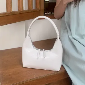 Minimalist white glossy crescent underarm bag soft leather stylish handbag detail view.