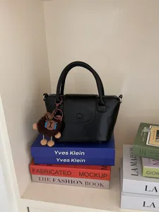Stylish black handbag for women, trendy small top handle bucket bag with cute plush charm.