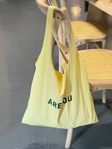 Hellgelbe Segeltuchtasche, lässige, leichte Umhängetasche Shopper mit grünem Buchstaben-Druck.