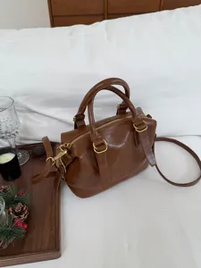 Retro brown bowling shoulder bag for women, versatile PU leather pillow handbag with top handles.