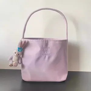 Detailed view of the taro purple nylon underarm bag featuring delicate embroidery and cute pendant.