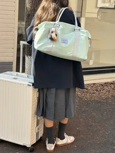 Lightweight waterproof travel duffel bag with luggage sleeve and cute penguin pendant.