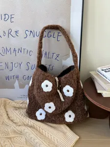 Detailed close-up of the brown fuzzy bag with cute white flower embroidery and soft texture.