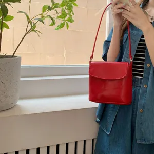 Detailed view of the Korean glossy red bucket bag, vintage flap design, crossbody mini purse.