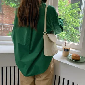 Minimalist solid color flap shoulder bucket bag detail showcasing daily commuting style and strap.
