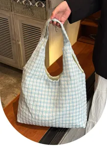 Detail shot of the blue and white plaid canvas shoulder tote bag, highlighting soft texture.