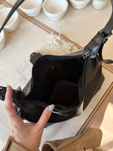 Detailed view of the black vintage soft leather shoulder bag interior, showing smooth zipper.