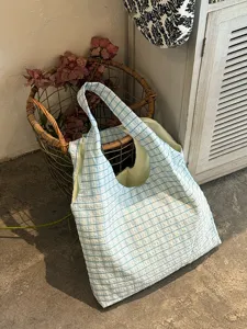 Detail view of a retro blue plaid canvas tote bag, casual large capacity shoulder bag style.