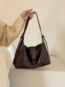 Vintage brown leather hobo bag detail shot, chic retro shoulder bag design for daily commuting.