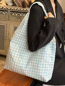 Close-up detail of Japanese vintage blue and white checkered canvas shoulder tote bag scene.