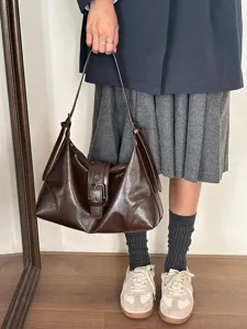 Detail shot of retro brown leather shoulder bag, soft texture and chic daily commuting style.