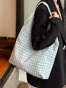 Detail view of a vintage blue and white plaid canvas shoulder tote bag, large capacity design.