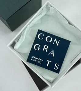 Detailed view of a minimalist graduation greeting card and gift box with letter print.