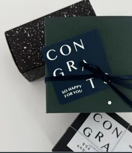 Graduation greeting card detail with minimalist English lettering and elegant gift box packaging.