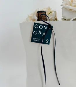 Graduation greeting card close-up, simple letter print design with black ribbon decoration.