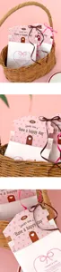 Vista dettagliata di carte di testa a forma di casa e sacchetti di carta con nastri regalo.