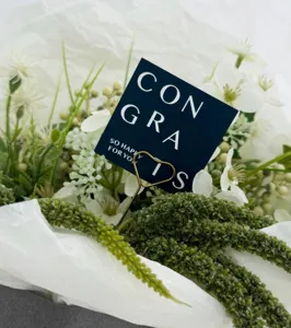 Graduation greeting card close-up showing stylish English blessing text and decorative heart clip.