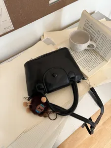 Small black PU leather handbag with top handles and shoulder strap for women daily wear.
