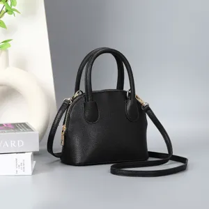 Black dome handbag detailed view, classic top handle purse with shoulder strap for women.