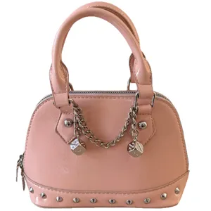 Pink patent leather dome handbag with metal rivets, trendy chain and stylish dice charms.