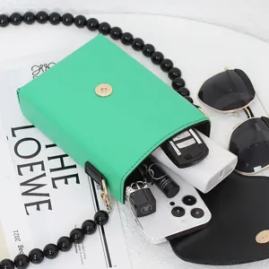 Grüne Mini-Handy-Umhängetasche mit schwarzer Perlenkette, Kapazitätsanzeige flach.