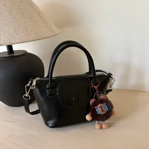 Black PU leather handbag for women, casual tote top handle bag with cute plush charm.