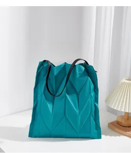 Geometric pleated tote bag detail view, showing unique diamond folds and texture.