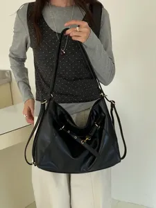 Detailed view of the black soft leather hobo shoulder bag, featuring stylish metal buckle accents.