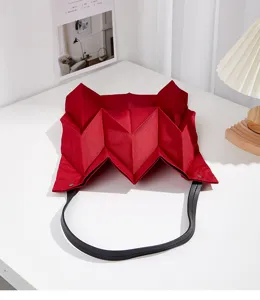 Detail shot of the red geometric pleated canvas tote bag showing its unique origami fold texture.