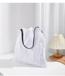 White geometric pleated canvas tote bag detail view, showing elegant design and clean aesthetic.