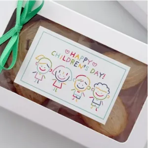 Adesivo per scatola regalo per bambini con grafica carina e nastro verde dettaglio.