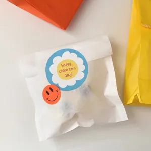 Detailed shot of children's day reward stickers on white paper bag, cute cartoon design.