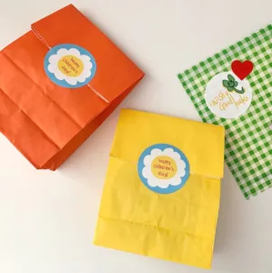 Colorful paper gift bags with cute children's day stickers, perfect for kids party favors.