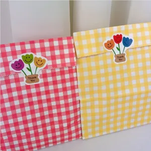 Karierte Papiertüten mit niedlichen Tulpen Smiley Aufklebern für kreative DIY Verpackung.