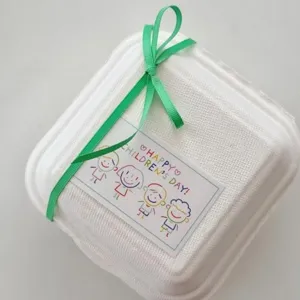 Scatola regalo bianca ecologica con nastro verde e simpatica carta decorazione per bambini.