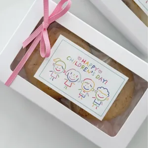 Scatola regalo per bambini con fiocco rosa e simpatica cartolina di festa per piccoli.