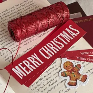 Set di confezioni regalo di Natale con spago metallico rosso, etichette e adesivi festivi.