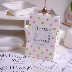 Close-up detail of DIY gift packaging stickers and polka dot baking bags with thank you text.