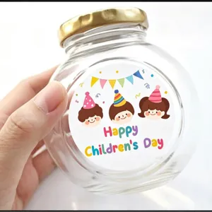 Klares Glasgefäß mit Golddeckel und niedlichem Kindertag Aufkleber für Geschenkverpackung