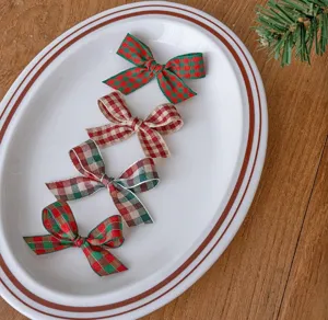 Vista dettagliata di nastri in tessuto scozzese di Natale e fiocchi decorativi sul piatto.