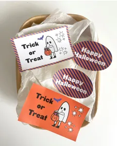 Dettaglio in primo piano di simpatici adesivi fantasma e zucca di Halloween per confezioni.