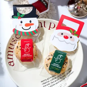 Emballage de biscuits de Noël avec de jolies cartes bonhomme de neige et père Noël.