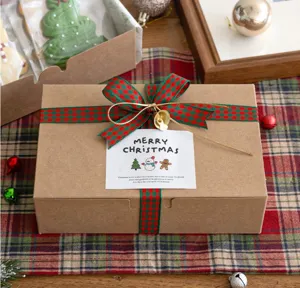 Dettaglio confezione regalo di Natale con nastro a quadretti rosso verde e biglietto.