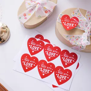 Red heart sticker sealing label with made with love text for gift box decoration.
