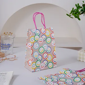 Bolsa de regalo de papel smiley colorida con asas rosas para fiestas y embalaje de panadería.