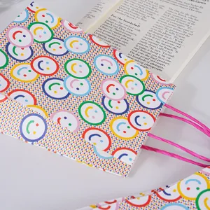 Detalle de bolsa regalo papel kraft con caritas sonrientes, ideal para panaderia y pasteleria.