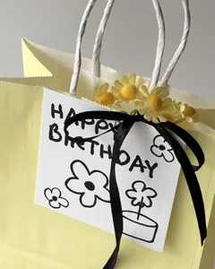 Close-up detail of happy birthday greeting card with black ribbon and cute daisy decor.