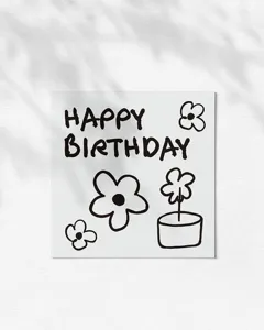 Detailed view of a minimalist birthday greeting card with cute hand drawn flower doodles.